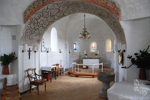 Der Altar mit Kronleuchter und Taufbecken in der Rundkirche in Nyker, Bornholm, Dänemark