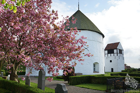 Blick auf den Friedhof der Rundkirche von Nylars mit Glockenturm, Bornholm, Dänemark